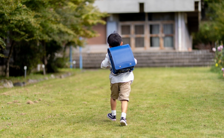 ブルーのランドセルを背負って歩く男の子